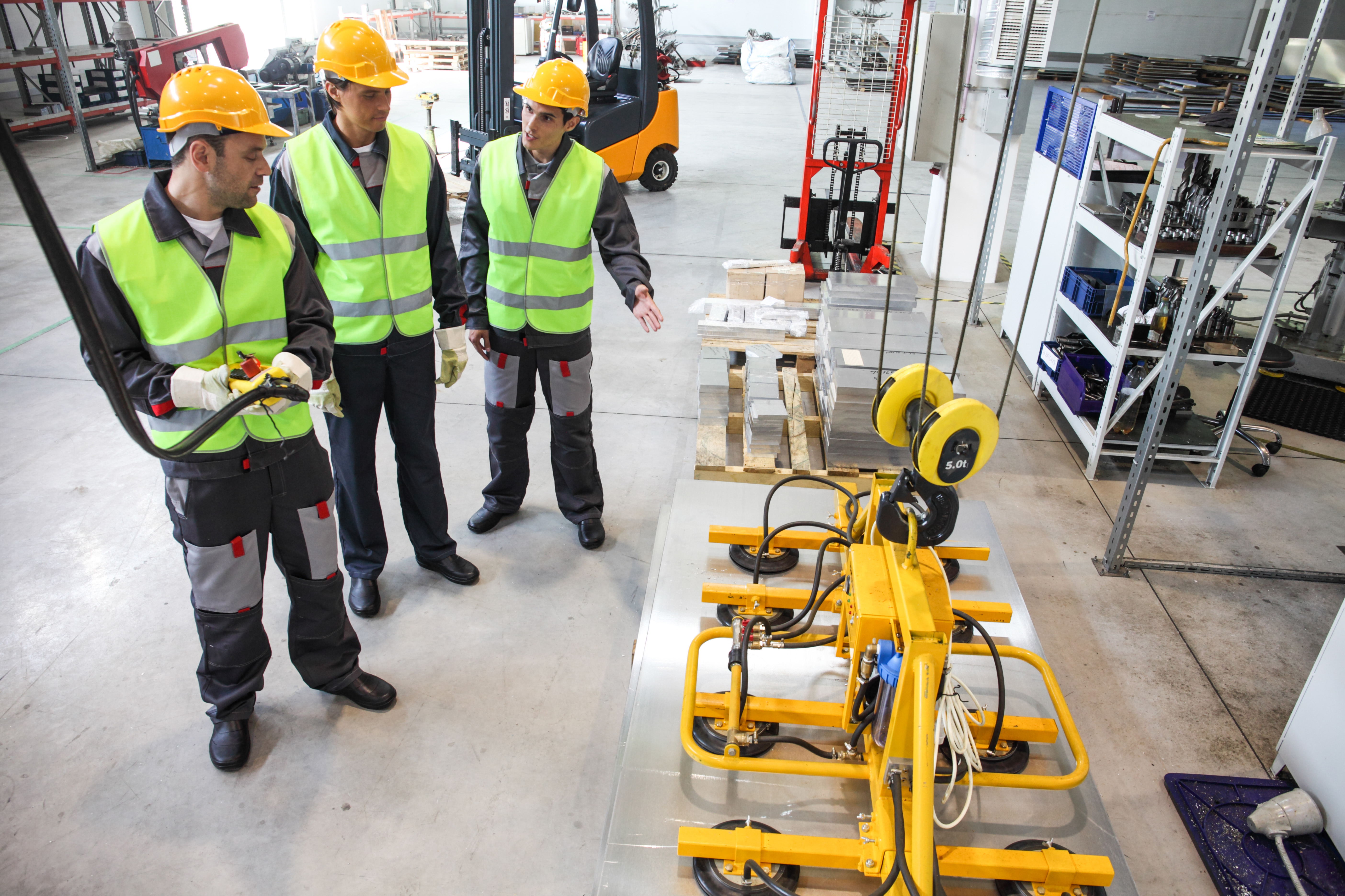 Industrial training instructor with workers in hi-vis and hard hats